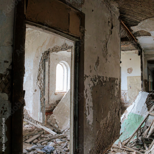 Interior of an abandoned, crumbling brick building in Krasnofarforny, Leningrad region, Russia, featuring broken walls and construction debris.