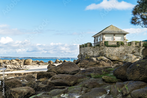 Un kiosque se dresse fièrement sur la falaise de Beg Meil, face à l’océan. Le ciel bleu d'automne est parsemé de quelques nuages blancs.