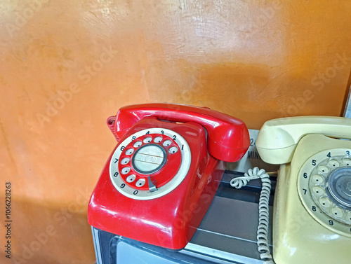 Old telephone with old television on orange wall natural light mobile photography