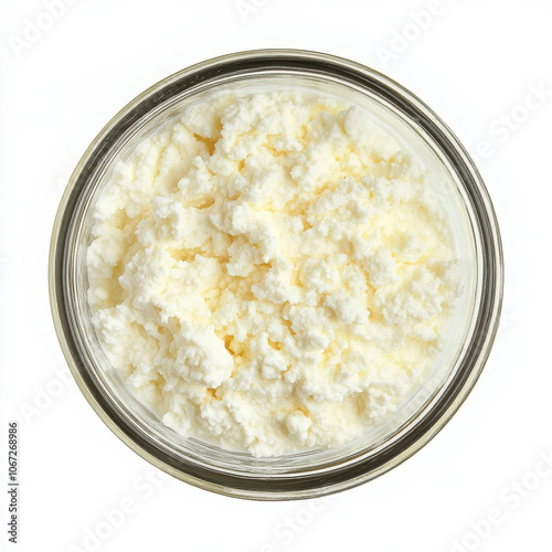 A small glass bowl filled with cottage cheese, showing its creamy, lumpy texture and richness, isolated on a white background