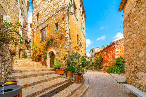 Colorful medieval stone buildings along the Grand Rue main street through the hilltop village of Tourrettes-sur-Loup, France, in the Alpes-Maritimes region of Southern France.