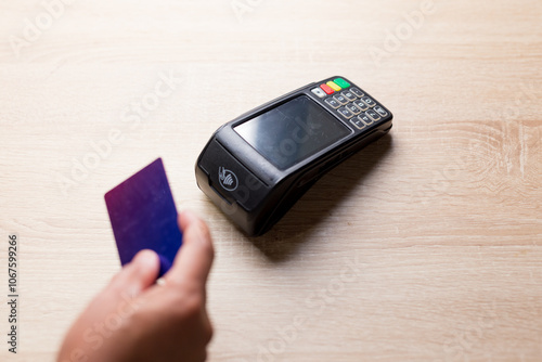 Customer paying with contactless credit card on pos terminal