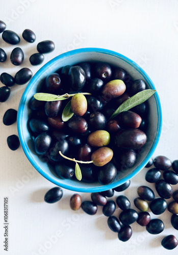 Olive fresche in una ciotola e olive isolate su un tavolo di legno bianco. Cibo mediterraneo, vegetariano e sano. Direttamente sopra.