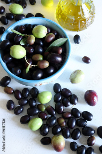 Olive fresche in una ciotola, olive e olio d'oliva isolati su una tavola di legno bianca. Cibo mediterraneo, vegetariano e sano. Direttamente sopra.