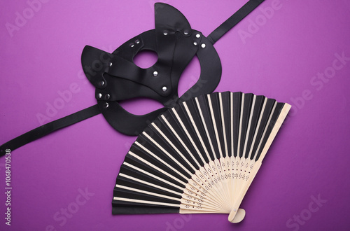 Leather erotic mask with fan on purple background. Sex games