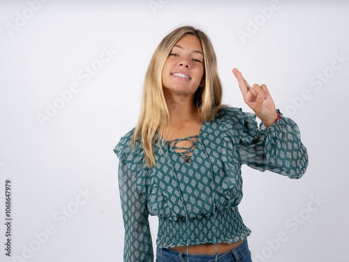 caucasian teen girl wearing green dress over white pointing up with fingers number ten in Chinese sign language Shi