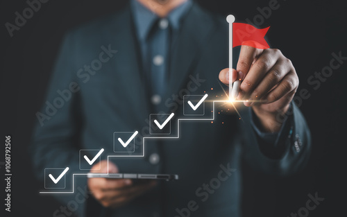 Business success and goal achievement steps. Businessman drawing checkmarks on virtual staircase steps toward achieving goals, ending with red flag as success marker. Planning, progress, goal setting,