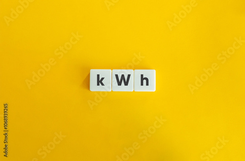 kWh acronym for Kilowatt-hour. The unit of energy that represents the amount of electricity consumed when one kilowatt of power is used for one hour. Text on block letter tiles on yellow background.