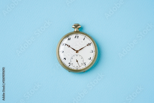 Top view of antique pocket watch on blue background