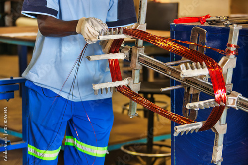 electrician with copper coils, motor rebuilding an electrical motor rewire, is rebuilding rewind the electric motor in a machine, adding copper