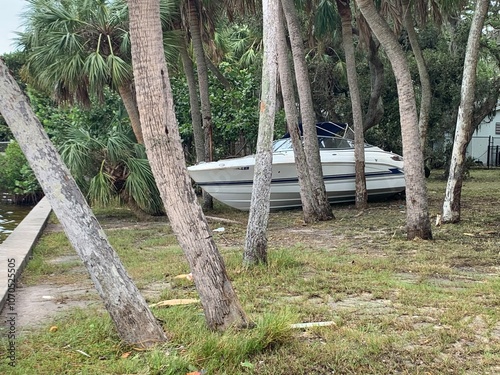 boat washed ashore between trees during hurricane storm surge