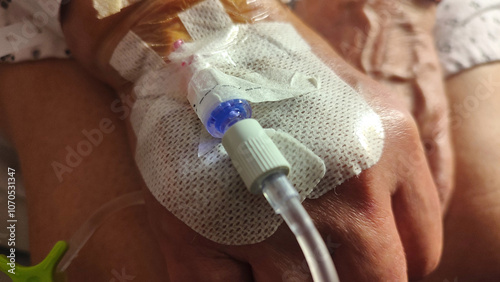 Infusion set taped to the hand of a hospitalized patient.