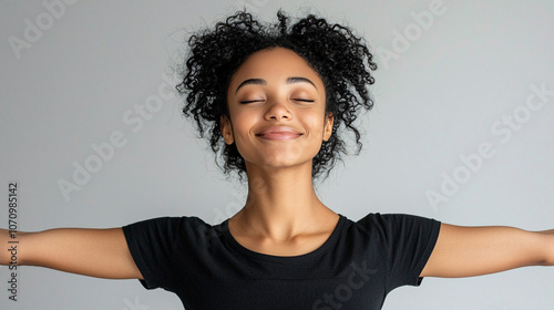 A cheerful female model displaying happiness with her arms raised, smiling widely in a studio setting against a white backdrop