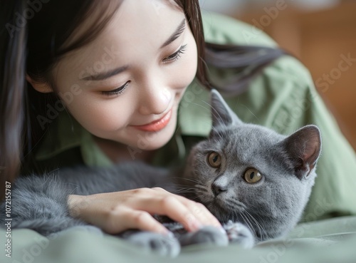 A young woman is petting a gray cat