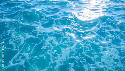 seething water. texture of blue foamy sea water. clear ocean water background. sun reflection