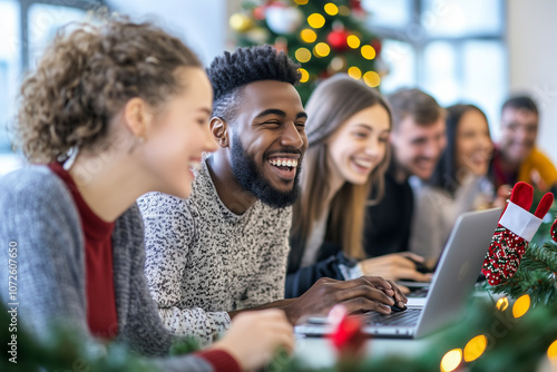 A group of people are sitting around a table with a laptop open