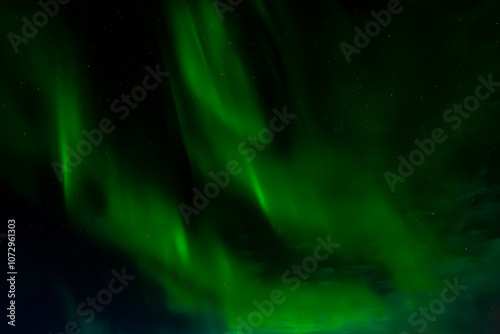 Abstract astrophotography of green aurora borealis on a starry sky in arctic circle of Alaska