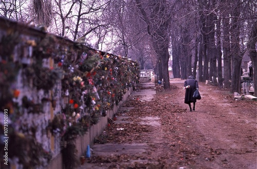 1994 circa. Old Woman Walking in Cemetery on Autumn Day. Budapest, Hungary