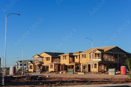 Two-story wooden single-family tract homes at different stages of construction in a new subdivision