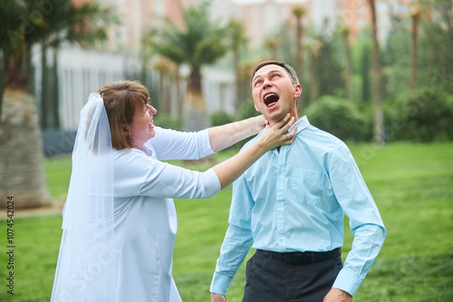 An adult bride and groom. Husband and wife photo shoot for the 30th wedding anniversary. An impromptu fight