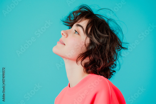 smiling woman in a bright oink sweater on blue studio background