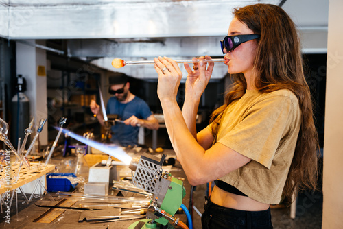 Glassblowing Studio: A Young Woman Blows Glass With a Torch