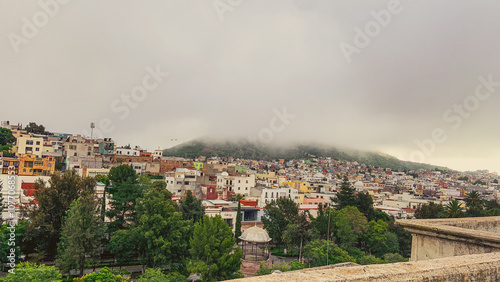 cerro de la bufa en zacatecas mexico, se observa que la densa neblina ntapa el iconico cerro dejando ver en un plano la alameda central de zacatecas en un dia de invierno 