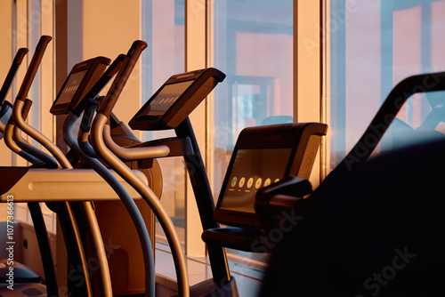 Close up of elliptical machine in gym at sunset.