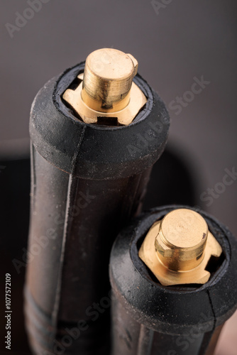 Close-up of cable plugs of an electrode holder and grounding clamp from a welding inverter machine, showing fine details of industrial connections.