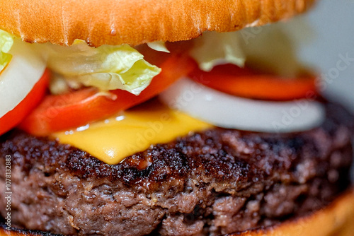 Una hamburguesa jugosa y perfectamente armada en primer plano, resaltando la textura dorada del pan, la carne suculenta y los ingredientes frescos que crean un plato irresistible.