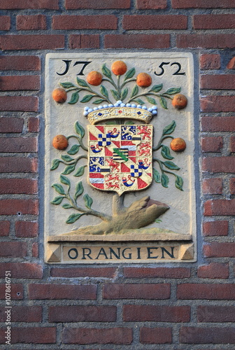 Historic Sculpted Tablet Depicting an Orange Tree and a Coat of Arms on a Brick Wall in Amsterdam, Netherlands