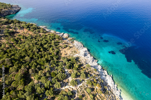 Turquoise waters lapping at rocky coastline of greek island