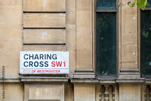 Close-up of the Charing Cross street sign in Westminster, London, featuring historic architecture and iconic SW1 postcode area designation.