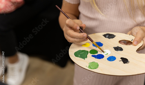 Children paint pictures with paints during additional didactic painting classes at school