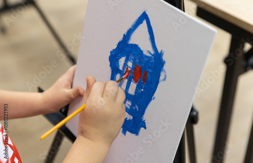 Children paint pictures with paints during additional didactic painting classes at school