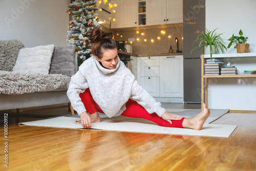 Woman doing yoga exercise at home during Xmas holidays.