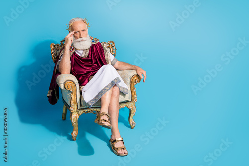 Full body portrait of minded aged man wear ancient roman senator costume sit throne empty space isolated on blue color background