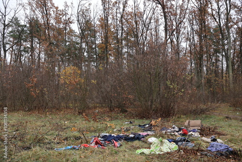 Trash in the forests of Ukraine. Bad irresponsible people pollute nature. Plastic bags, old clothes, trash are scattered across the lawn. Animals are suffering