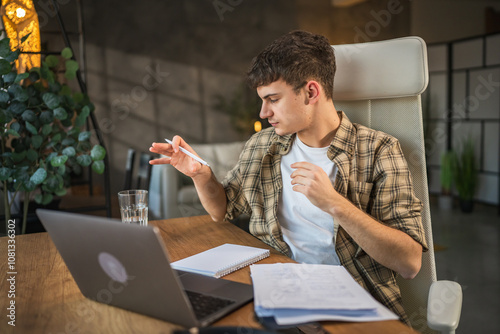 Focused young adult man write notes in notebook prepare for exam