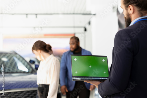 Salesperson using green screen laptop, negotiating price and car features with clients to help solidify deal. Showroom worker persuading hesitant customers to buy vehicle using chroma key notebook