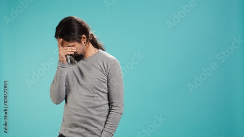 Portrait of troubled man feeling saddened and rattled by bad news, isolated over studio backdrop. Distressed person on the verge of crying, left speechless by troubling events, camera B