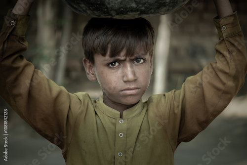 A Young Indian Boy Carrying a Heavy Load