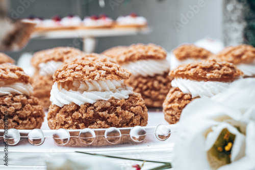 Close-up of elegant cream-filled choux pastries with a golden, crunchy topping. The rich texture and intricate design make them a perfect addition to a refined dessert table.