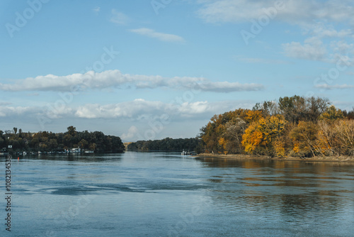 autumn landscape with danube river passing by the colorful green and orange leaves trees