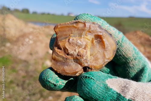 Flint concretion fragment in hand, rockhounding, field photo. Russia