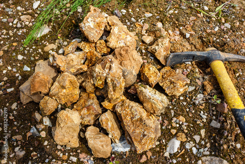 Chunks of chert rock collected in a pile, extracting rocks from the ground with a pickaxe