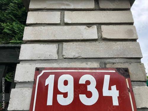 Red metal sign that says 1934