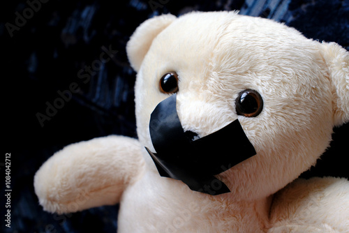 Teddy bear with tape on his mouth. Symbol of silence during child abuse