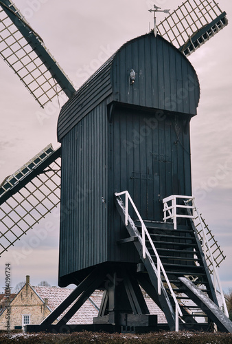 A winter view of the historic replica windmill on the Bourtange fortress moat during a snowy Christmas market.