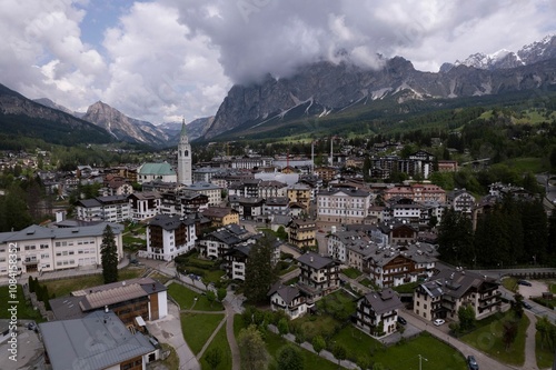 Cortina d'Ampezzo town surrounded by the Dolomite mountains and cloudy sky in Italy